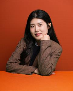 Headshot of Junghyun Lee on red orange background