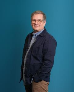 Headshot of Anthony Chemero blue background