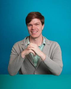 Headshot of Stephen Bryant on blue and green background.