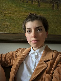 Woman in white shirt and brown jacket