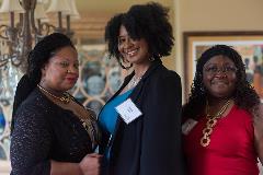 Three black women posing for the camera at event