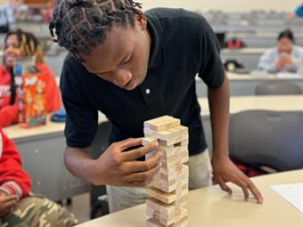 Close-up student moving Jenga blocks in Project Management activity Close-up student moving Jenga blocks in Project Management activity